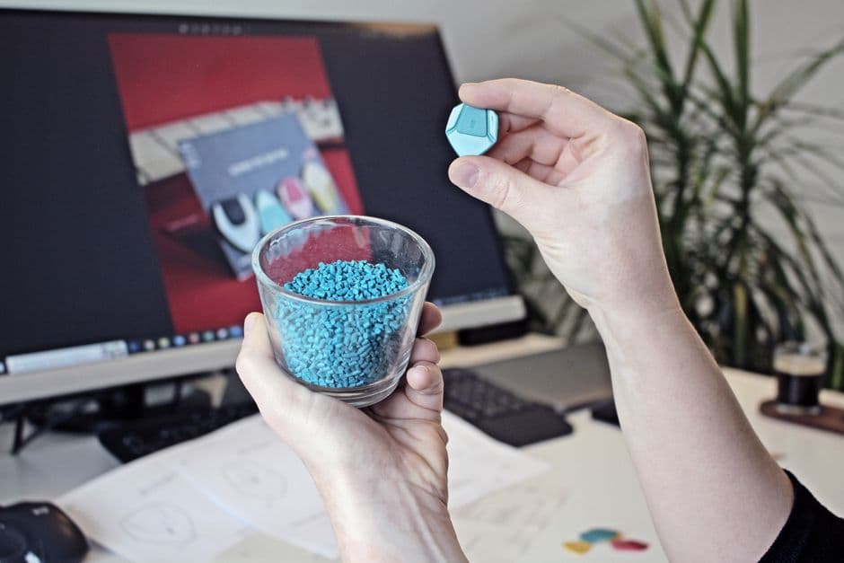 Hands holding recycled plastic resin granules